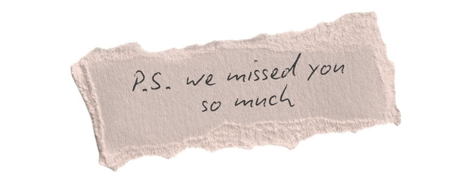 Torn piece of paper with 'P.S. we missed you so much' text on a white background